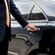 A private driver opening the door of a luxury sedan